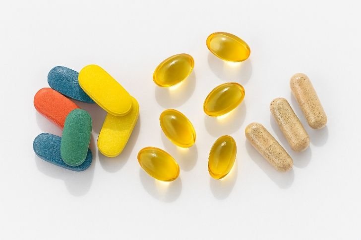 Multivitamins and supplements with vitamin D capsules and herbal boosters on white background.